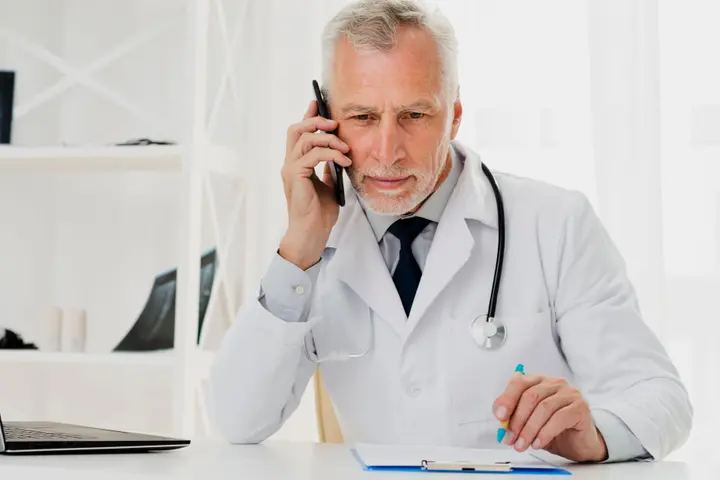 Un médecin-dentiste répond au téléphone à son bureau